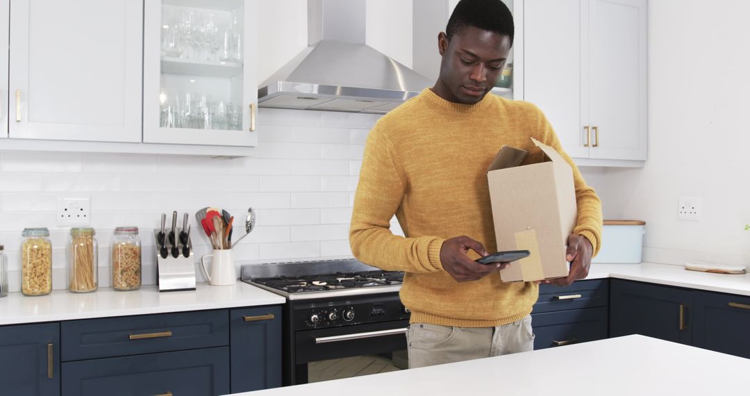 Man Scanning Package in Modern Kitchen with Smartphone