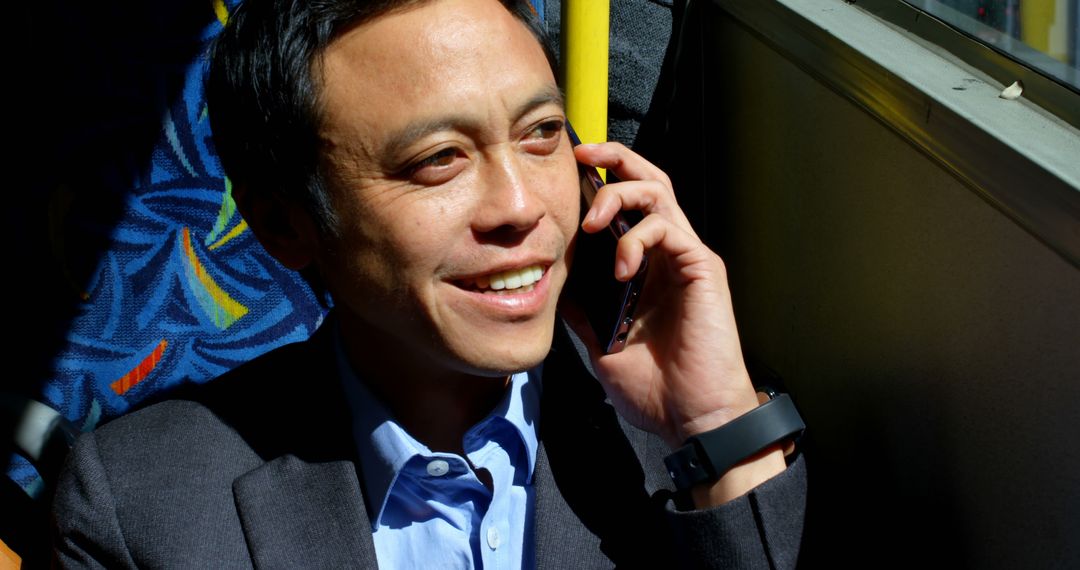 Businessman Talking on Phone During Commute on Bus - Free Images, Stock Photos and Pictures on Pikwizard.com