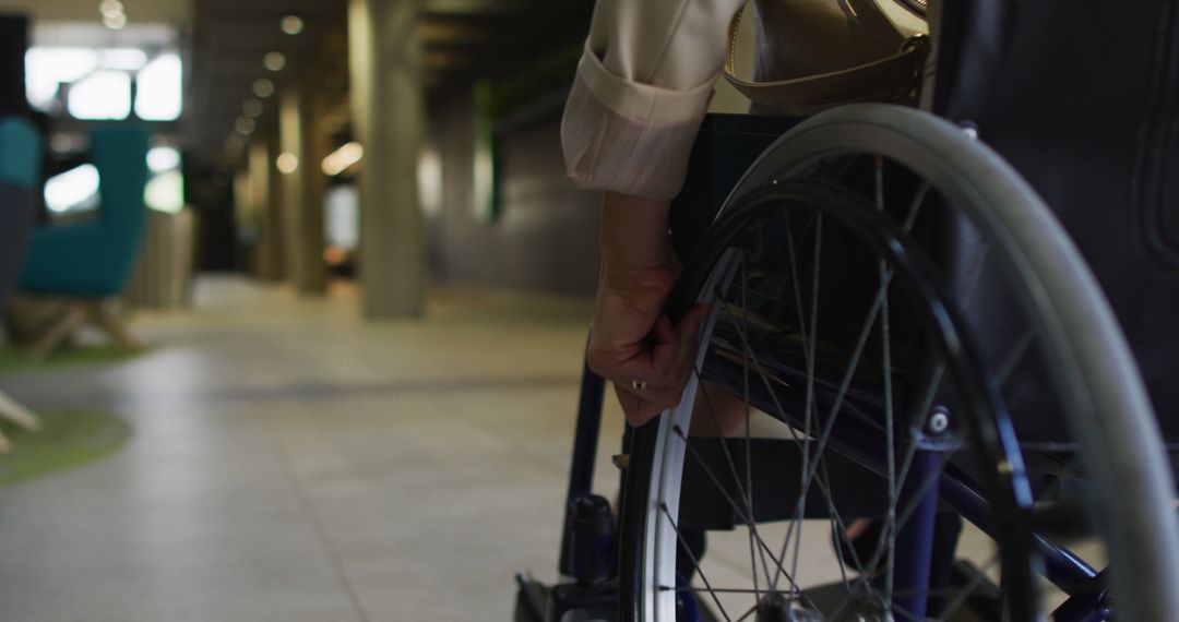 Business Person in Wheelchair Navigating Office Hallway - Free Images, Stock Photos and Pictures on Pikwizard.com