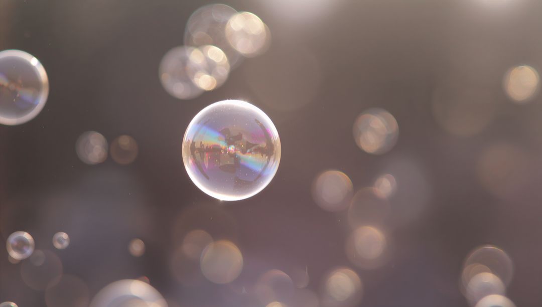 Iridescent soap bubble floating with soft bokeh and sunlit pastel glow