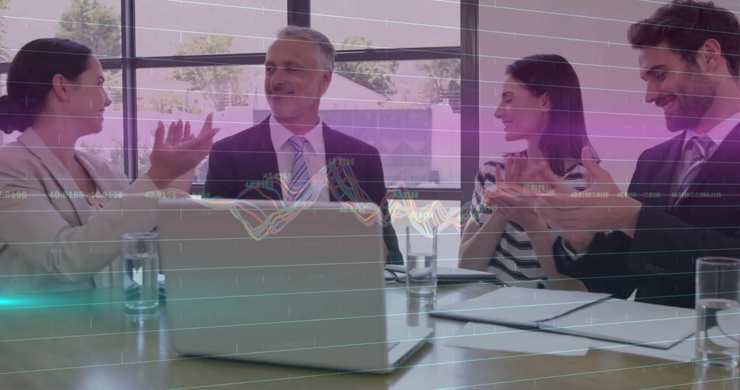 Team Celebrating Success in Modern Office Setting with Laptops and Graphics