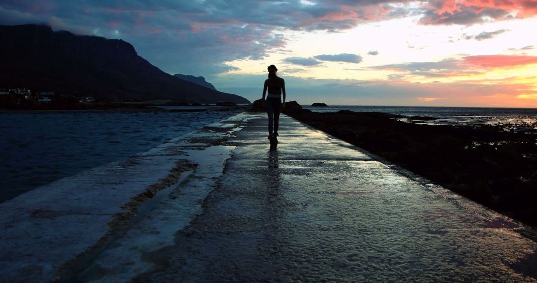 Silhouette of Woman Walking on Coastal Path at Sunset - Free Images, Stock Photos and Pictures on Pikwizard.com