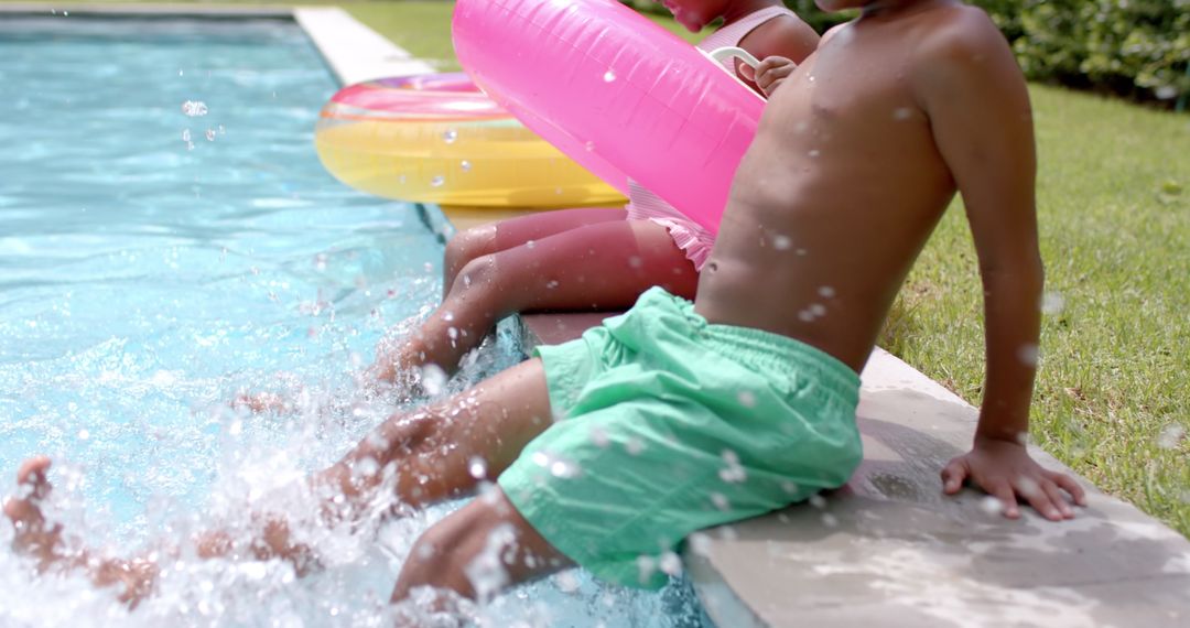 Joyful Siblings Splashes at Poolside with Bright Floats
