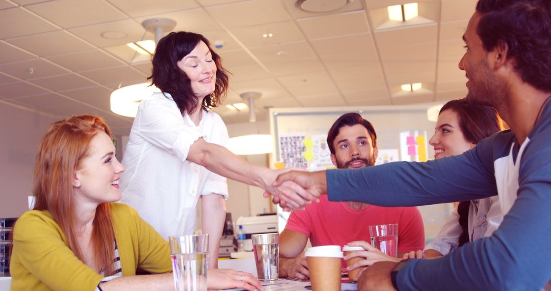 Diverse Professionals Shaking Hands in Modern Office Collaboration