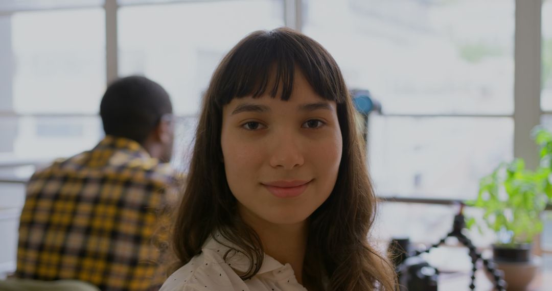 Confident Woman in Modern Office Setting Smiling at Camera