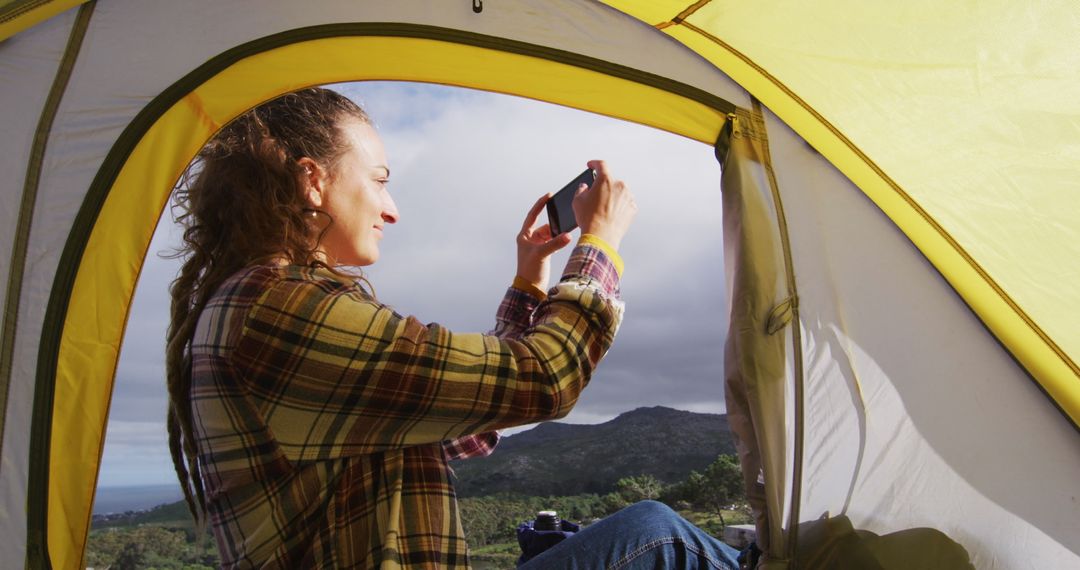 Woman taking photo from tent, enjoying nature - Free Images, Stock Photos and Pictures on Pikwizard.com