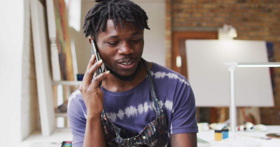 African American Artist Conversing While Creating Art in Studio