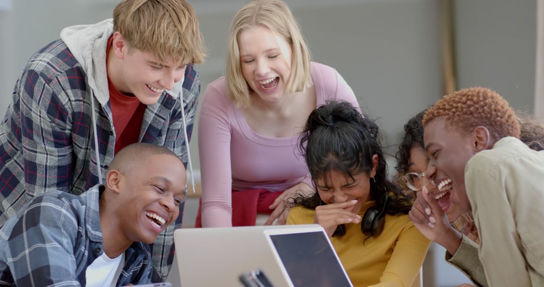 Diverse Group of Young Friends Laughing Together at a Laptop - Free Images, Stock Photos and Pictures on Pikwizard.com