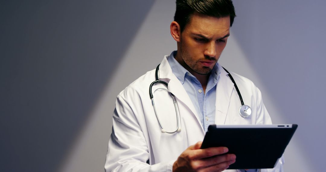 Focused Doctor Reviewing Patient Records on Tablet - Free Images, Stock Photos and Pictures on Pikwizard.com