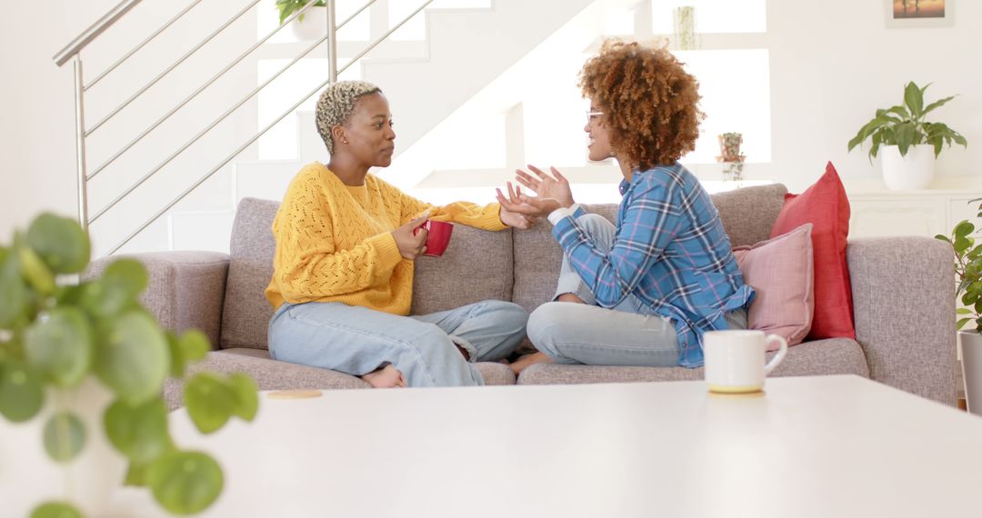 Two Women having Heartfelt Conversation on Cozy Couch in Bright Living Room - Free Images, Stock Photos and Pictures on Pikwizard.com