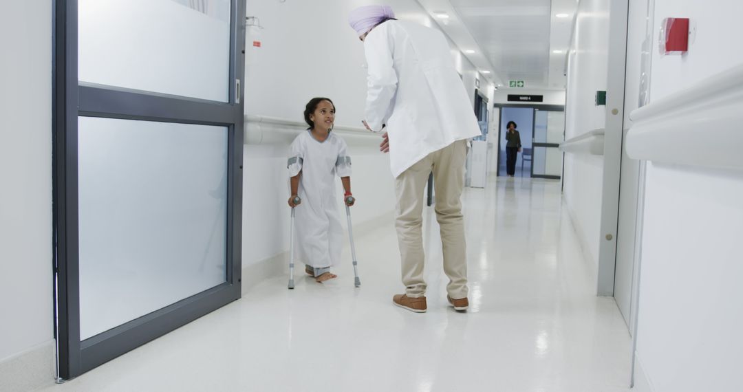 Doctor Assisting Patient with Crutches in Hospital Corridor - Free Images, Stock Photos and Pictures on Pikwizard.com