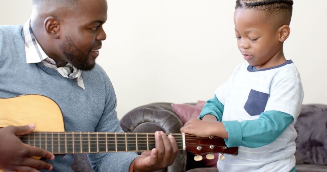 Father Teaching Son to Play Guitar in Cozy Living Room - Free Images, Stock Photos and Pictures on Pikwizard.com