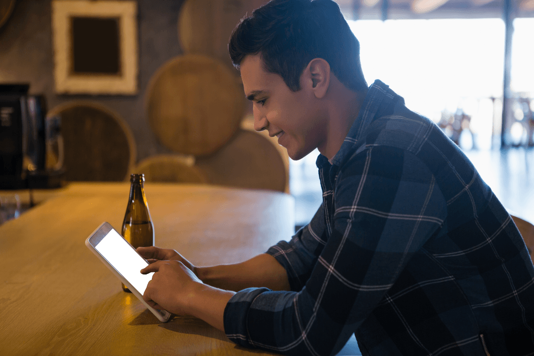 Young Man Using Transparent Digital Tablet in Modern Cafe