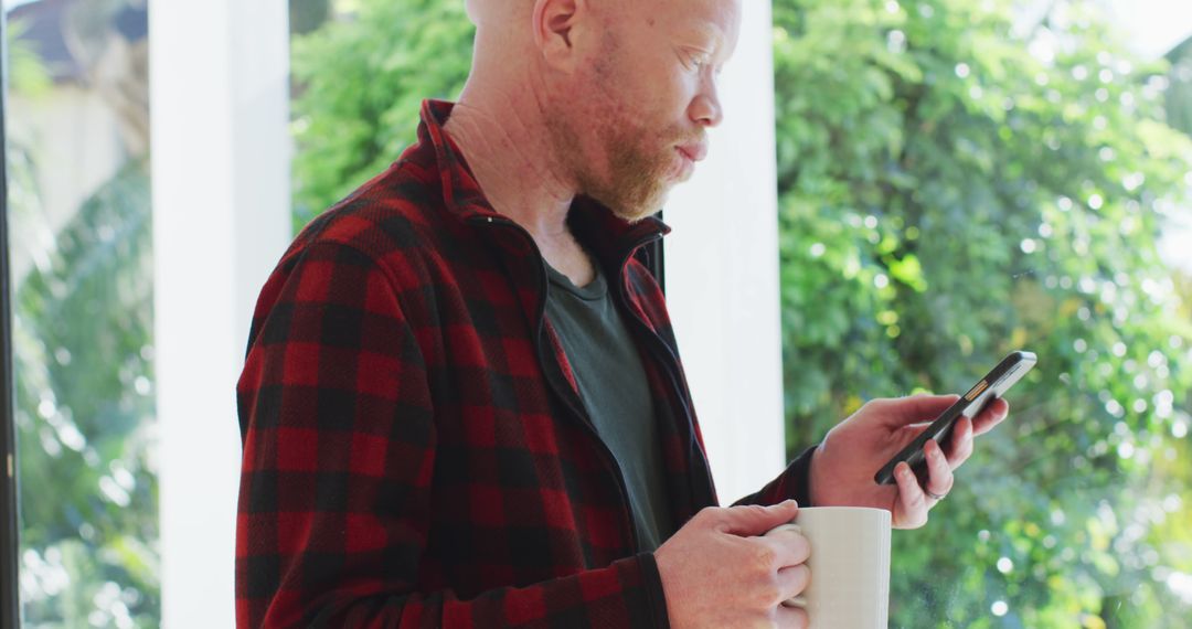 Albino African American Man Using Smartphone and Drinking Coffee