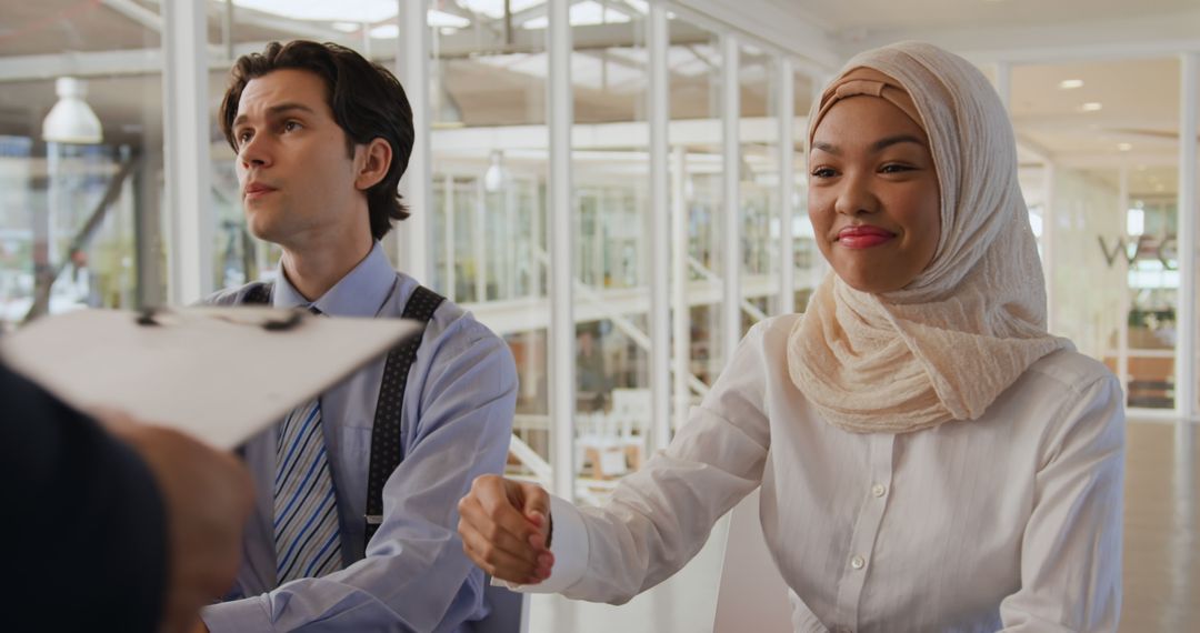 Diverse Colleagues Engaging in Handshake at Modern Office