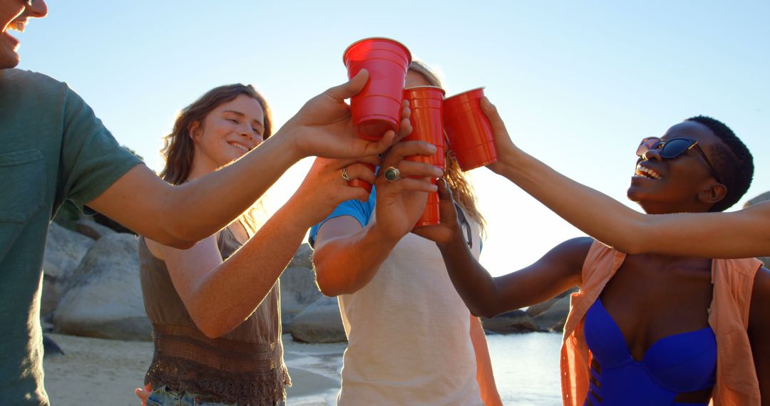 Group of Friends Celebrating on Beach with Red Cups - Free Images, Stock Photos and Pictures on Pikwizard.com