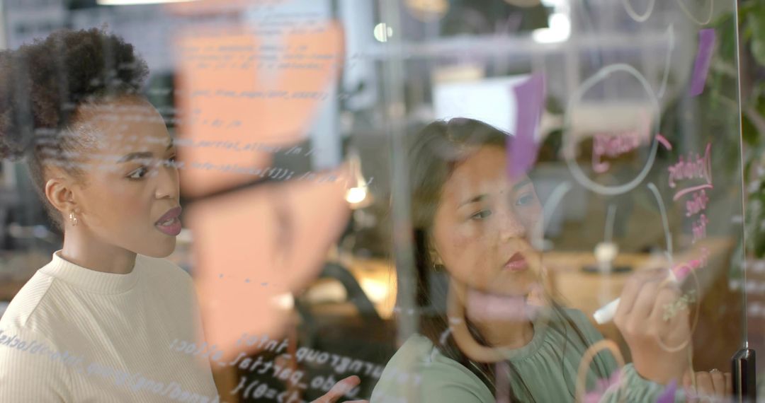 Two Professional Women Developing Innovation Strategies in Open-Plan Workspace