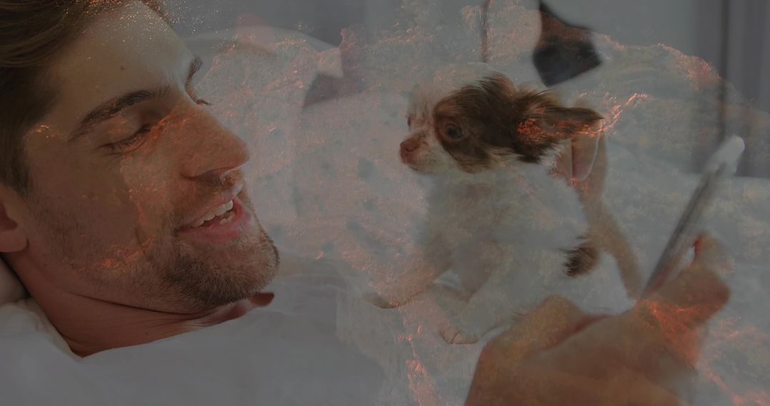 Man Relaxing in Bed While Video Calling with Puppy