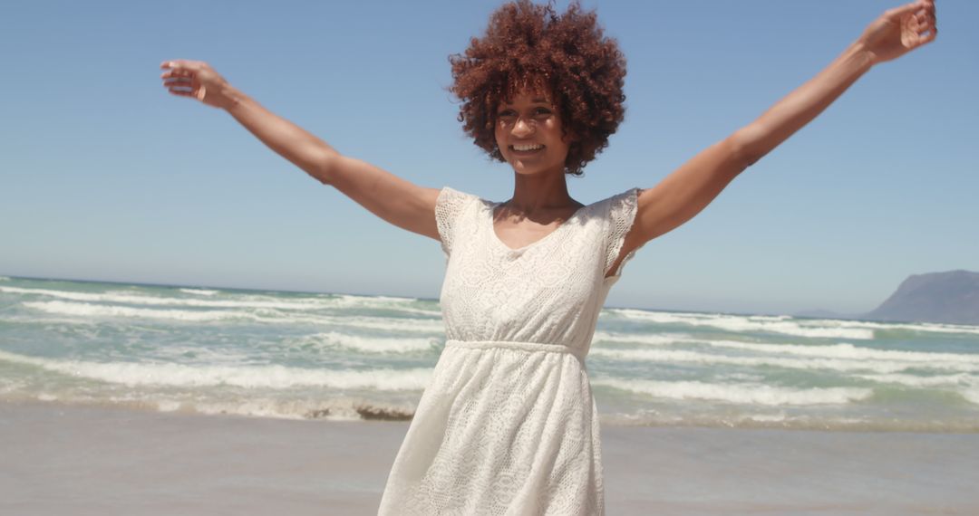 Joyful Woman in White Dress with Arms Raised at Sunny Beach - Free Images, Stock Photos and Pictures on Pikwizard.com