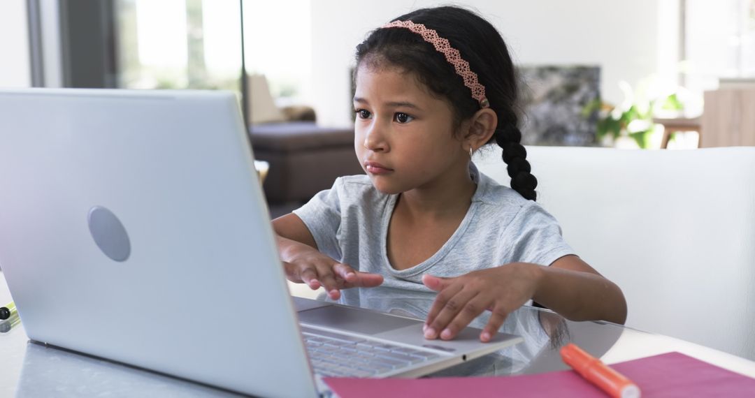 Child Engaged in Remote Learning on a Laptop in Modern Living Space
