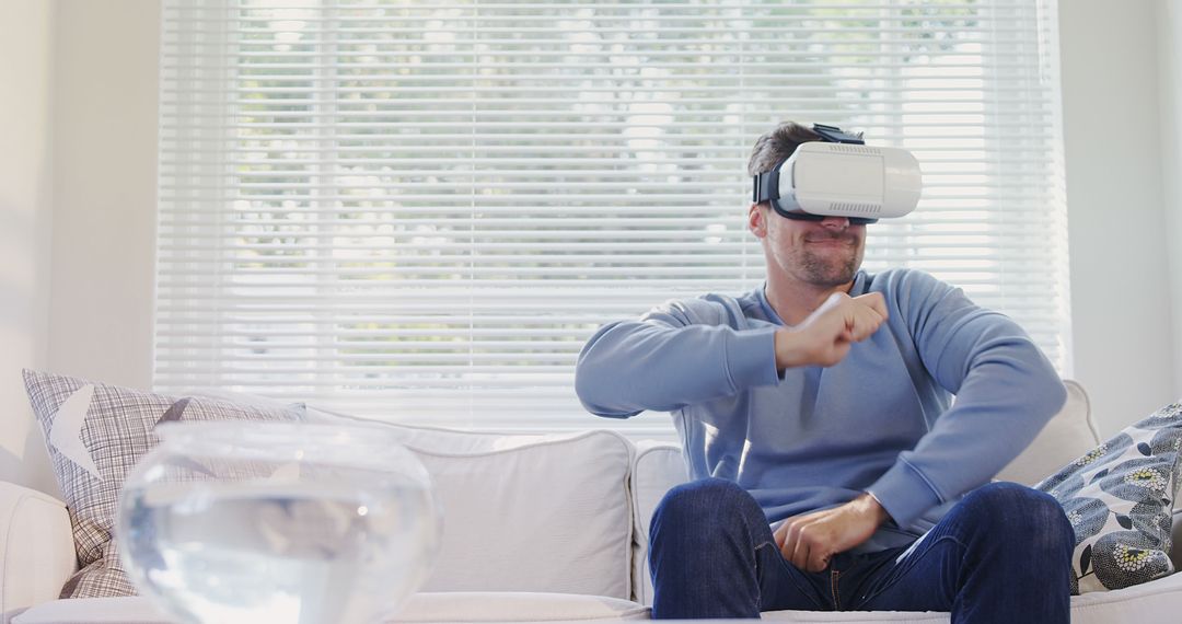 Man in Blue Sweatshirt Using Virtual Reality Headset in Modern Living Room - Free Images, Stock Photos and Pictures on Pikwizard.com