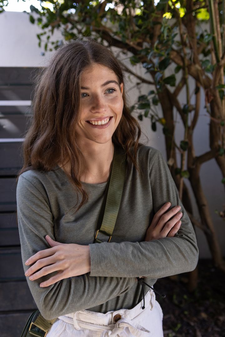 Woman Posing on Patio with Canvas Bag Among Lush Greenery