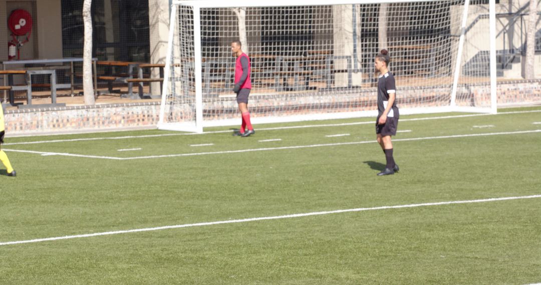 Juvenile Soccer Game with Red Uniformed Goalkeeper in action