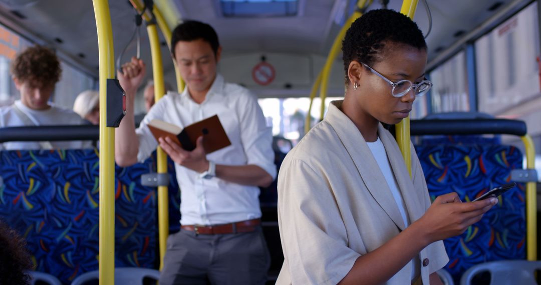 Commuters aboard bus using smartphone and reading book during transit - Free Images, Stock Photos and Pictures on Pikwizard.com