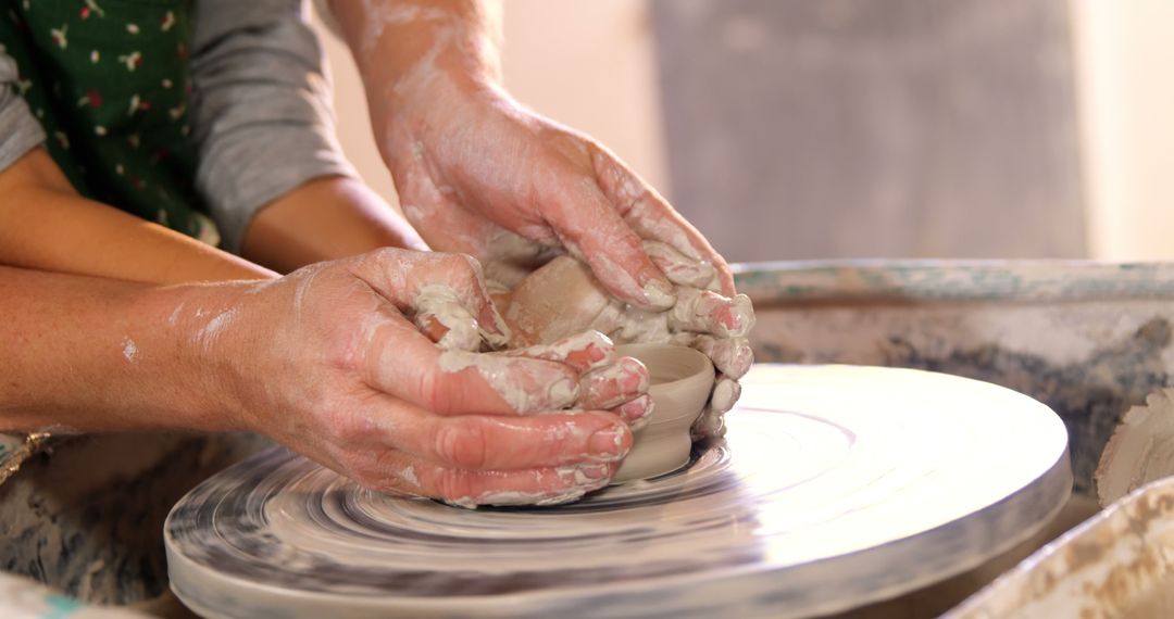 Hands Crafting Pottery Together on Spinning Wheel - Free Images, Stock Photos and Pictures on Pikwizard.com