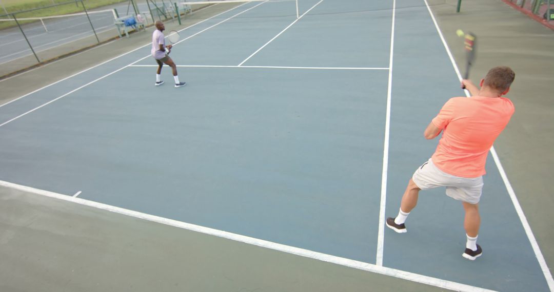 Men Practicing Tennis on an Outdoor Court on a Sunny Day - Free Images, Stock Photos and Pictures on Pikwizard.com