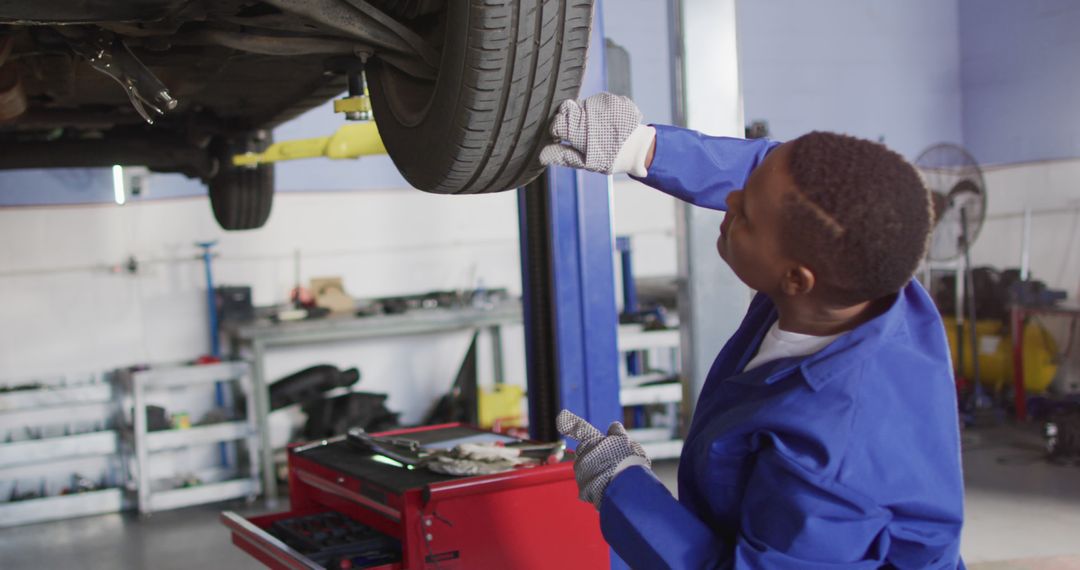 Auto Mechanic Inspecting Car Tire in Repair Shop - Free Images, Stock Photos and Pictures on Pikwizard.com