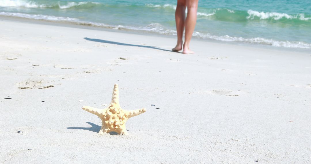 Starfish on Sandy Beach with Waves and Legs in Background - Free Images, Stock Photos and Pictures on Pikwizard.com