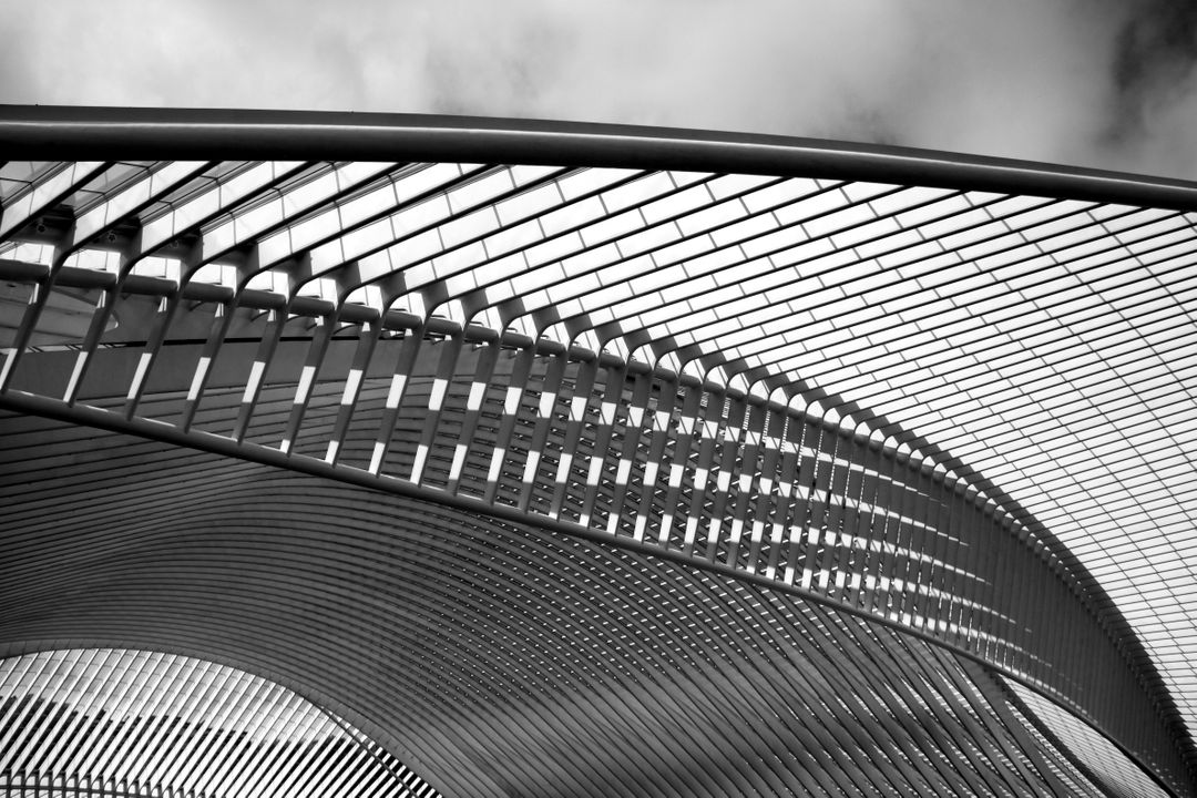 Sleek Metal Architecture Against Cloudy Sky in Black and White - Free Images, Stock Photos and Pictures on Pikwizard.com