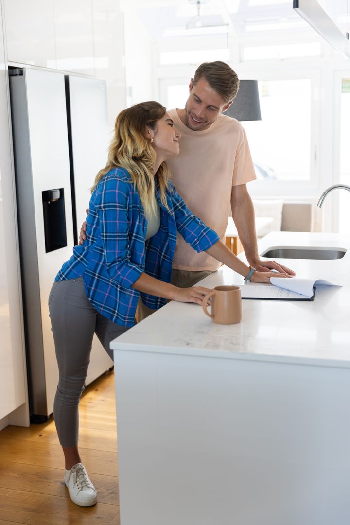 Couple Reading Notebook Together in Modern Kitchen Setting