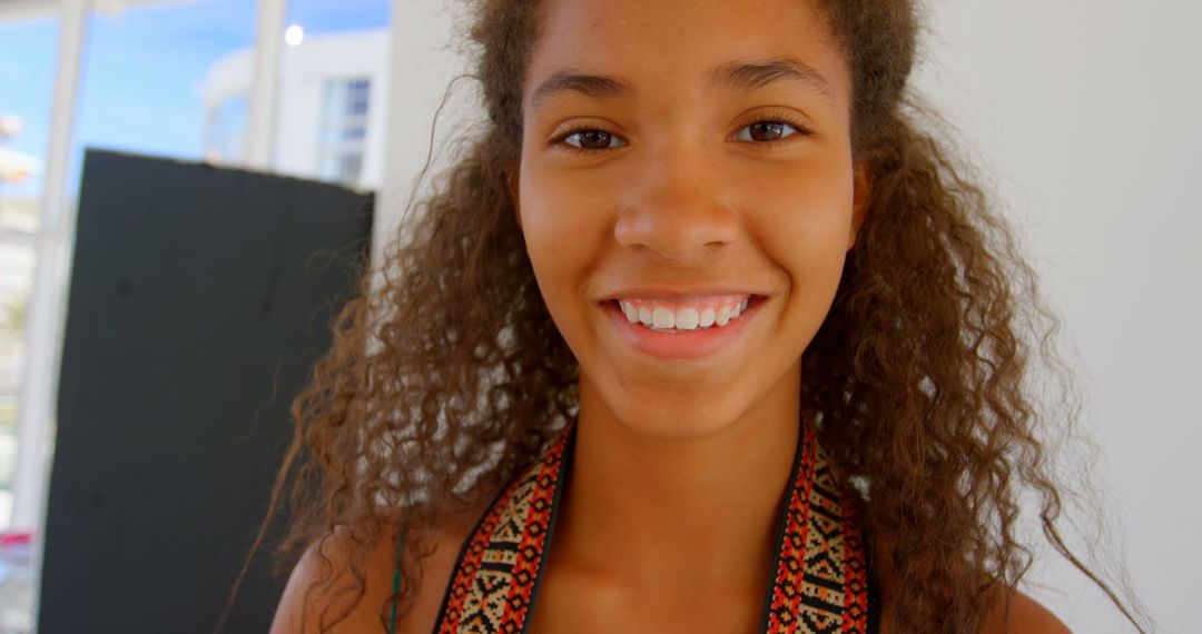 Smiling African American Teen Girl with Curly Hair Indoors - Free Images, Stock Photos and Pictures on Pikwizard.com