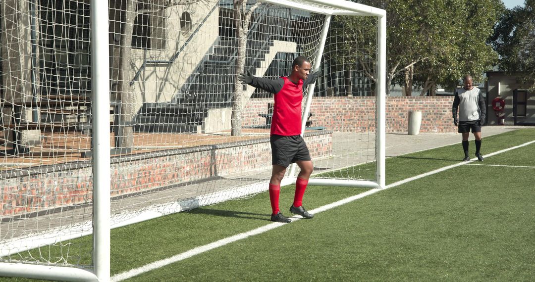 Goalkeeper in Red Jersey Ready to Defend Goal During Soccer Practice