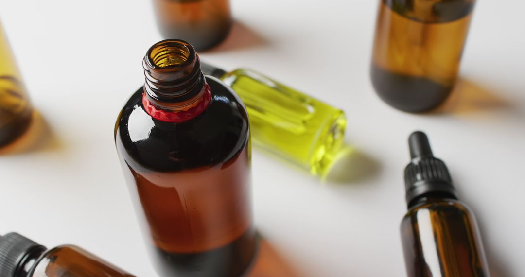 Various Amber and Green Glass Bottles with Essential Oils on White Background - Free Images, Stock Photos and Pictures on Pikwizard.com