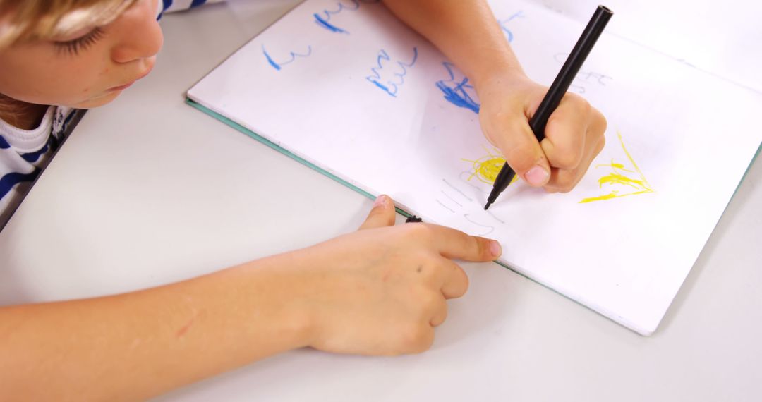 Child Drawing in Notebook with Pen, Engaged in Creative Activity - Free Images, Stock Photos and Pictures on Pikwizard.com