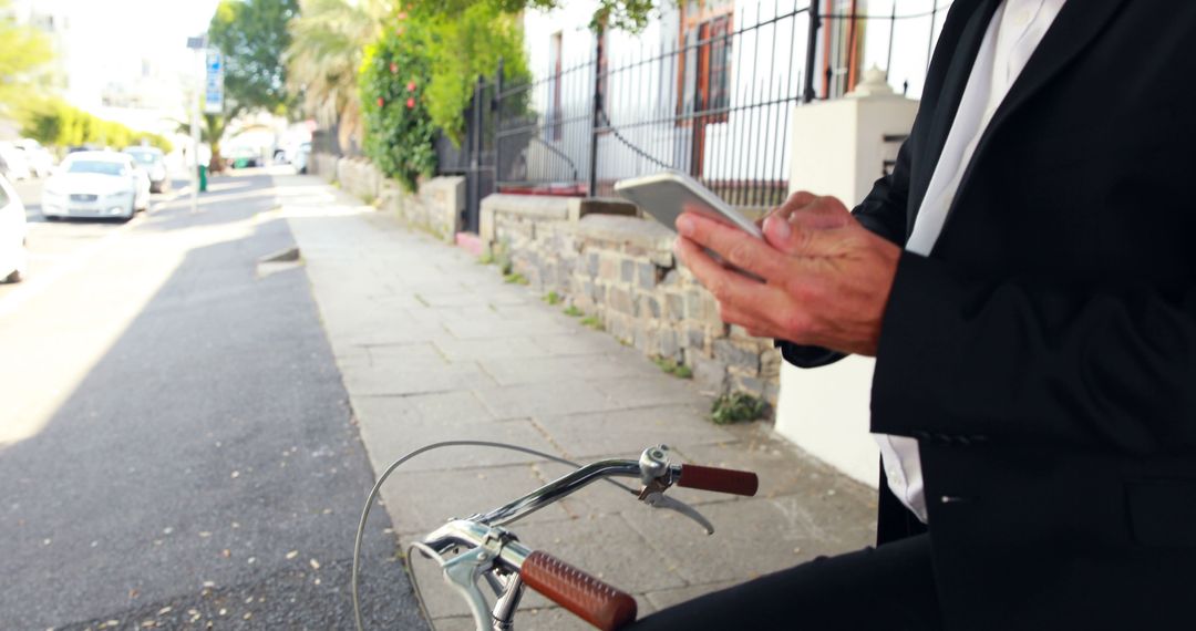 Businessman on Bike Using Smartphone on Urban Sidewalk - Free Images, Stock Photos and Pictures on Pikwizard.com