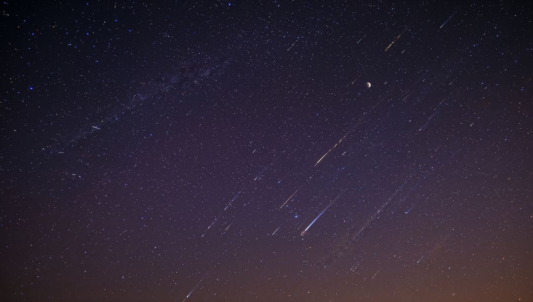 Milky Way Arching across Night Sky with Meteor Streaks, Crescent Moon and Star Trails