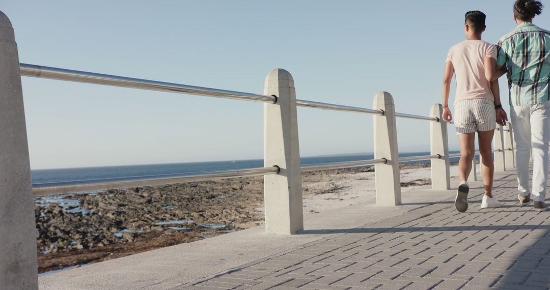 Diverse Couple Walking on Beachfront Promenade in Summer