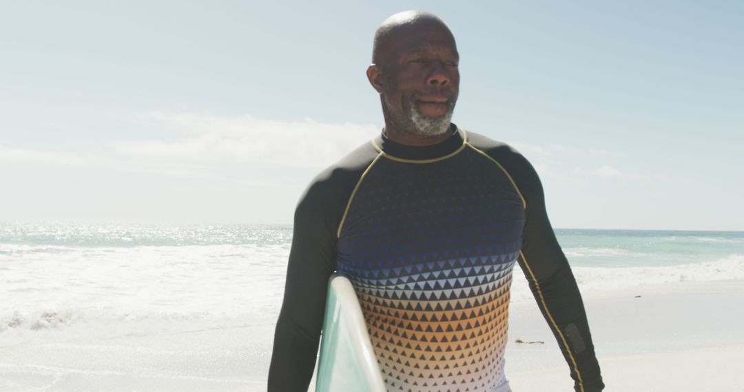 Senior Man Holding Surfboard on Sunny Beach - Free Images, Stock Photos and Pictures on Pikwizard.com