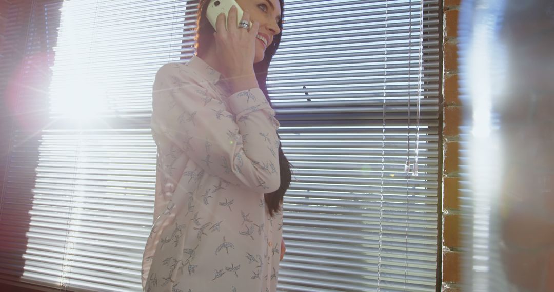 Businesswoman Talking On Smartphone Near Sunlit Window - Free Images, Stock Photos and Pictures on Pikwizard.com