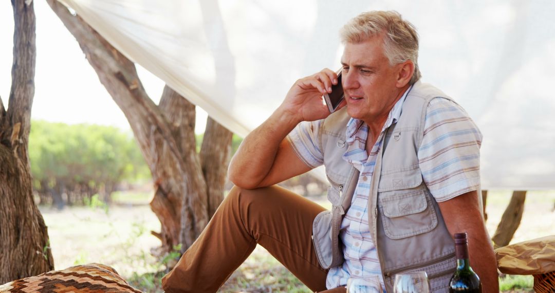 Senior Man Talking on Phone During Outdoor Picnic - Free Images, Stock Photos and Pictures on Pikwizard.com