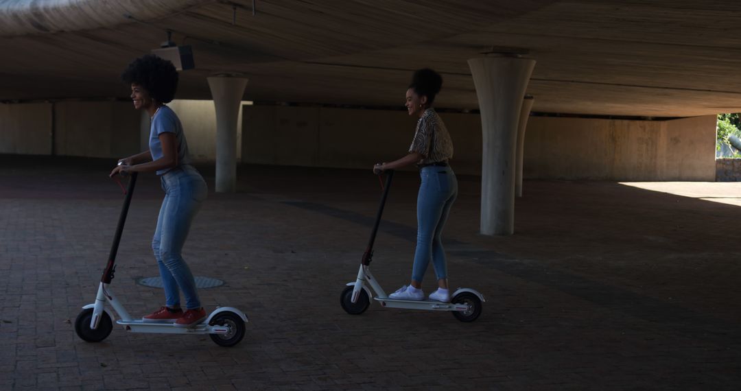 Young women riding electric scooters in urban setting - Free Images, Stock Photos and Pictures on Pikwizard.com