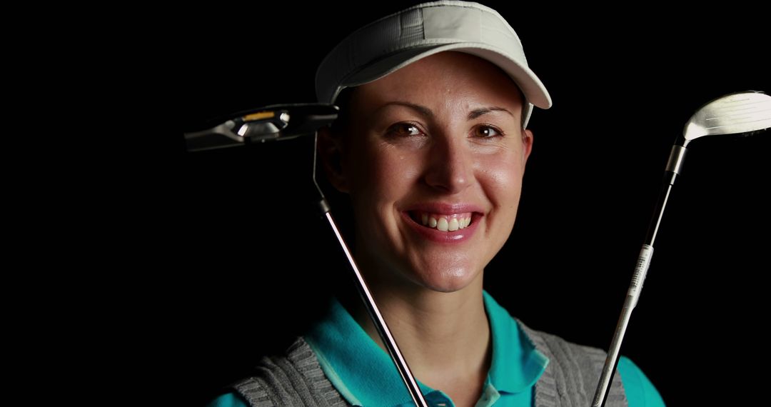 Female Golfer Smiling Holding Two Golf Clubs Against Black Background - Free Images, Stock Photos and Pictures on Pikwizard.com