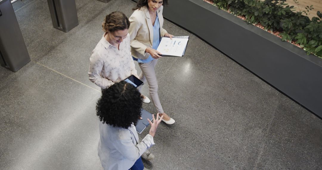 Diverse Female Colleagues Discussing in Modern Office Foyer