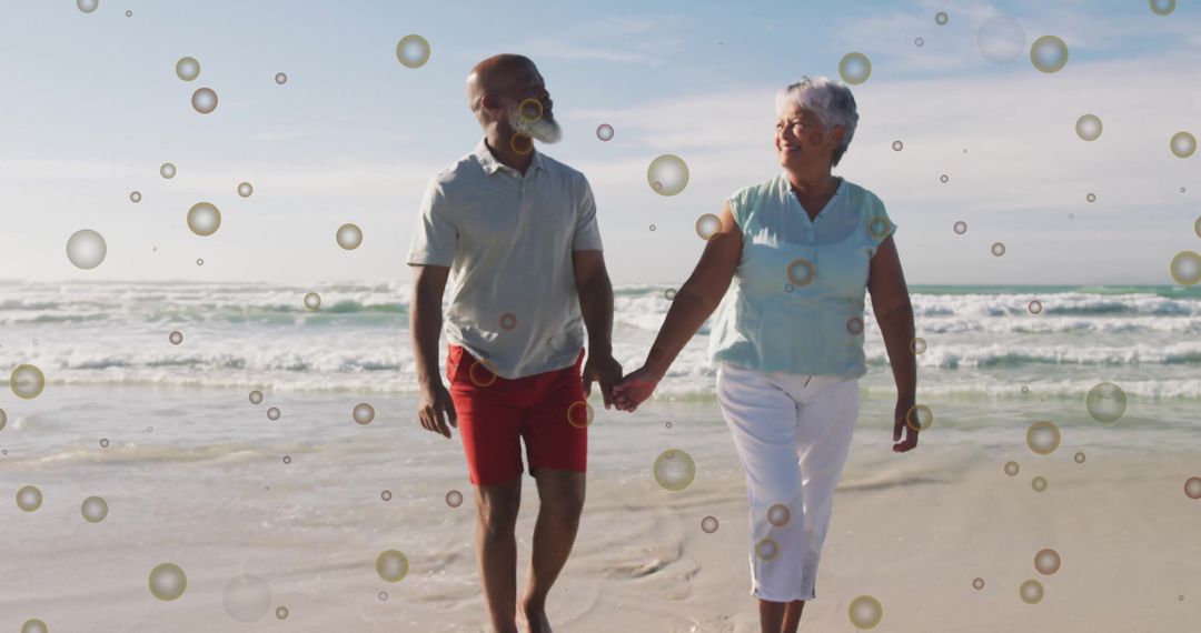 Senior Couple Holding Hands on Beach with Floating Bubbles