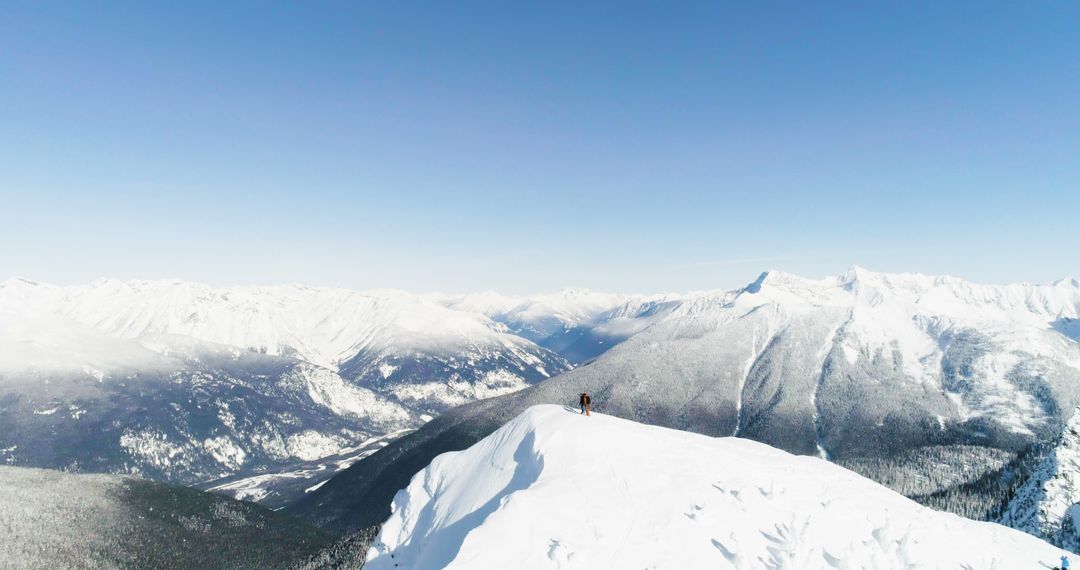 Lone Hiker on Snowy Mountain Ridge with Panoramic Views