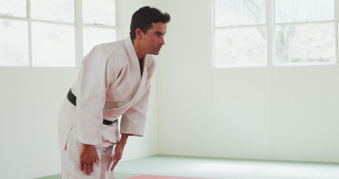 Karate Master Bowing in Traditional White Dojo - Free Images, Stock Photos and Pictures on Pikwizard.com